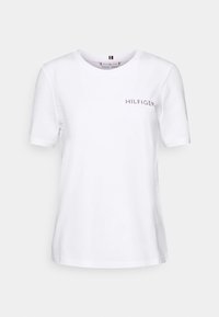 Bílá bavlněná tričko s krátkými rukávy, kulatým výstřihem a malým logem "HILFIGER" z kamínků na levé straně hrudníku.
