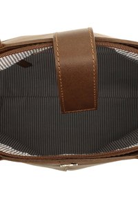 Brūna ādas soma ar augšējo rāvējslēdzēju atvērtu, atklājot iekšpusi, kas oderēta ar melnu un baltu vertikālu svītru audumu.