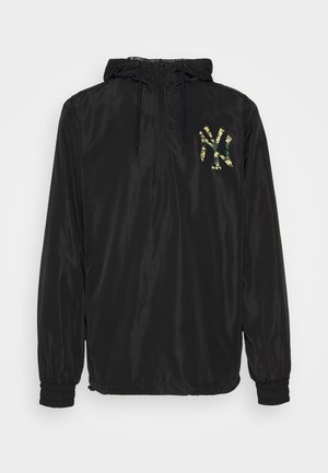 Schwarze Windjacke mit Kapuze, halb durchgehendem Reißverschluss, elastischen Bündchen und einem grünen Camouflage-New York Yankees-Logo auf der Brust.