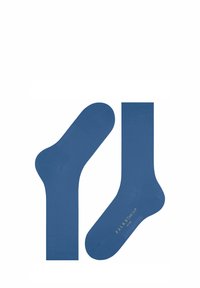 Chaussettes en coton bleues avec une texture lisse, présentant des poignets côtelés et une marque imprimée sur la semelle. Conçues dans une longueur classique de type mi-mollet.