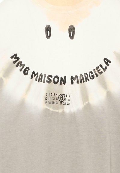 Tissu blanc avec un visage souriant noir, le texte incurvé "3M6 Maison Margiela" et un chiffre 6 entouré d'un cercle au milieu d'une grille de petits chiffres.