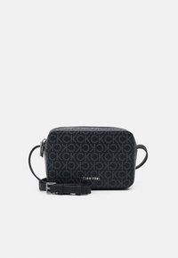 Geantă crossbody neagră Calvin Klein, cu închidere cu fermoar, curea ajustabilă și model monogram pe țesătură texturată.