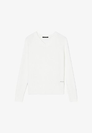 Maglione bianco con scollo a V, maniche lunghe, polsini e orlo a costine. Texture morbida, design minimalista, con un piccolo logo decorativo nella parte inferiore.