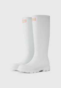 White rubber rain boots with a smooth finish, round toe, and textured white sole. Features red "HUNTER" logo on upper side.