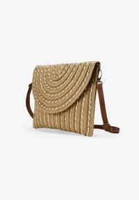 Bolso de paja tejido con una tapa curva en beige, que presenta líneas texturizadas y un acento de hilo dorado. Asa ajustable marrón para llevar al hombro.