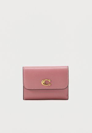 Pink leather wallet with a gold clasp logo, featuring a smooth texture, fold-over flap, and contrasting stitching detail.