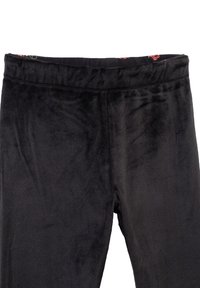 Leggings neri realizzati in morbido tessuto peluche con vita elasticizzata. L'interno della vita presenta un motivo floreale.