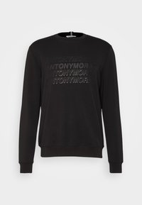 Sudadera negra con cuello redondo, mangas largas y un diseño texturizado con logotipos repetidos en la parte frontal. Tejido suave.