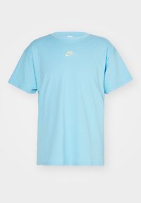 Ljusblå bomulls T-shirt, kort ärm, rund hals, med en liten vit Nike-logotyp på bröstet. Slät textur, avslappnad design.