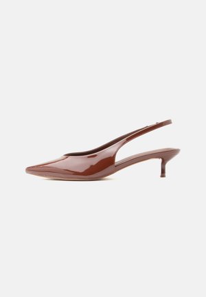 Escarpin slingback brun brillant à talon kitten pointu avec bout pointu et talon bas et fin sur fond blanc.