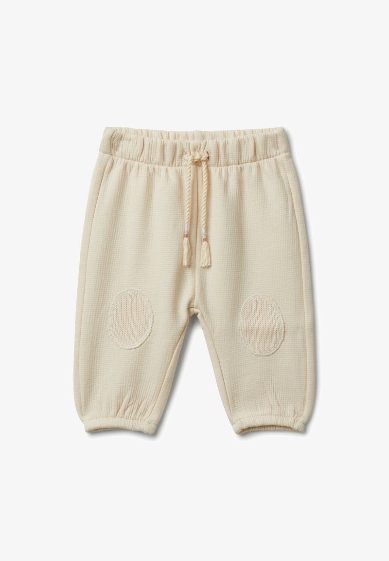 Beżowe bawełniane spodnie typu jogger z teksturowanym materiałem, elastycznym pasem i dzianinowymi naszywkami na kolanach. Zawierają regulowany sznurek.