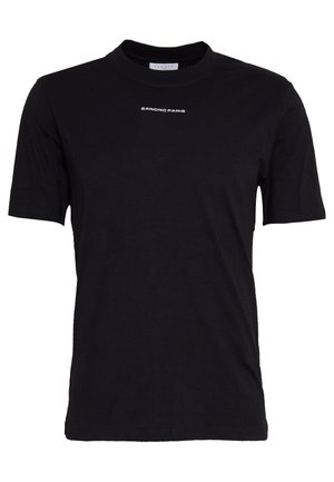 Musta puuvillapaita lyhyillä hihoilla ja pyöreällä kaula-aukolla. Edessä on valkoisella painettu "SANDRO PARIS" -logo rinnan kohdalla. Yksinkertainen muotoilu.