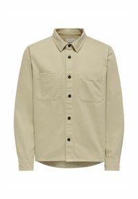 Beige Hemd aus Baumwolle mit Knopfleiste. Verfügt über einen Hemdkragen, zwei Brusttaschen und schwarze Knöpfe. Glatte Textur mit geradem Saum.