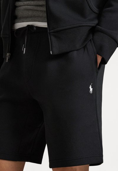 Black fleece shorts featuring a drawstring waistband, side pockets, and a white embroidered logo on the left side. Smooth texture.