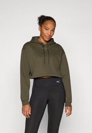 Oliven grønn cropped hettegenser med snor, med "HYROX" logo på forsiden. Kombinert med svarte høyt liv leggings, begge fra Puma.