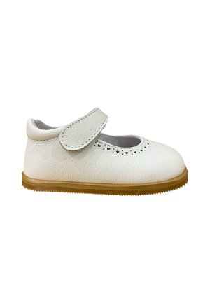 Zapato de cuero blanco con punta redondeada, correa de velcro ajustable y detalles decorativos perforados. Suela de goma con agarre texturizado.