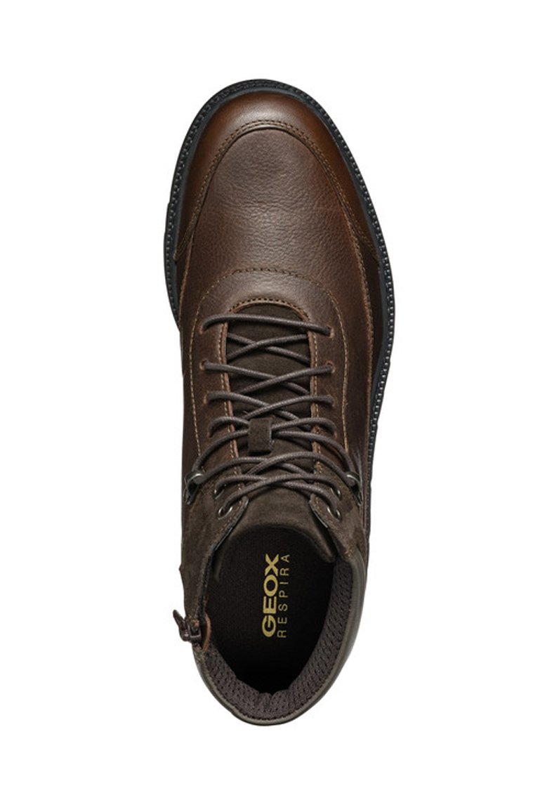 Bottine en cuir marron et en daim, présentant un bout rond, un système de laçage et un logo Geox sur la semelle intérieure. Semelle extérieure robuste et texturée.