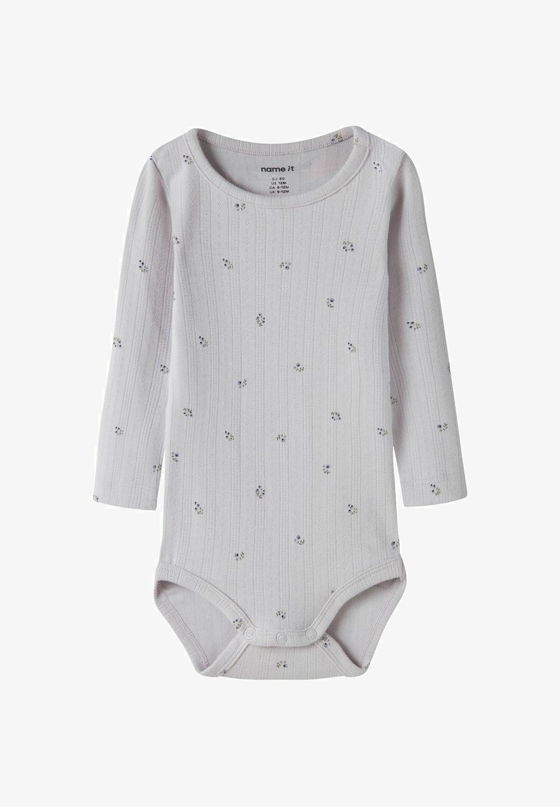 Body blanc côtelé à manches longues pour bébé avec de petites impressions florales bleues et des boutons-pression en bas, destiné aux bébés de 9 à 12 mois.
