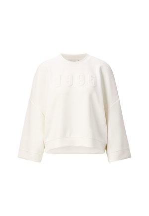 Sweatshirt blanc avec l'année "1995" en relief sur le devant. Il a une coupe décontractée, des manches larges et un ourlet côtelé. Texture de tissu douce.