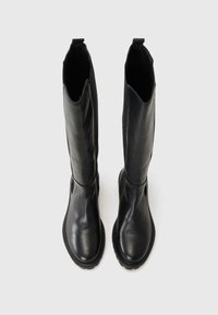Bottes noires en cuir hautes avec un bout arrondi et de subtils détails de couture, présentées sur un fond blanc.