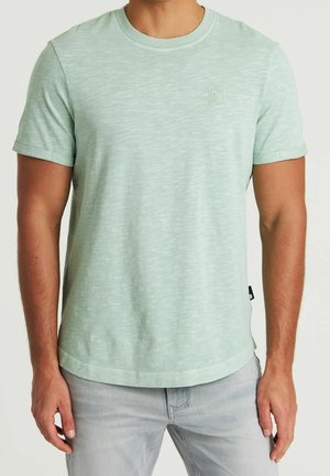 T-shirt vert clair à manches courtes en tissu doux et texturé. Présente un logo discret sur la poitrine et un col arrondi.