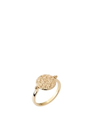 Bague en or avec un disque rond texturé présentant des motifs complexes en relief sur un anneau lisse, présenté sur fond blanc.