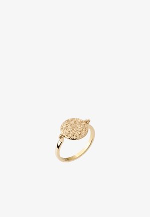 Bague en or avec un disque rond texturé présentant des motifs complexes en relief sur un anneau lisse, présenté sur fond blanc.