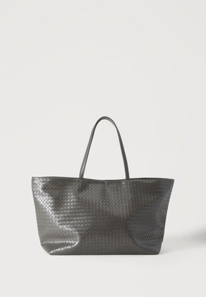 Sac cabas en cuir tissé noir avec deux poignées, debout sur un fond clair.