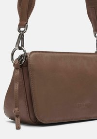 Brown leather crossbody bag with a smooth texture, featuring a detachable strap, silver hardware, and a knot detail on the side.
