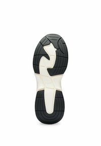 Black rubber shoe sole with white midsole. Features a wavy tread pattern and central branding. Designed for grip and stability.