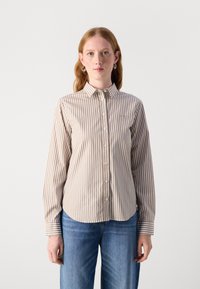 Camicia a righe beige e bianca, con colletto, maniche lunghe e orlo arrotondato. Tessuto morbido con una consistenza liscia.