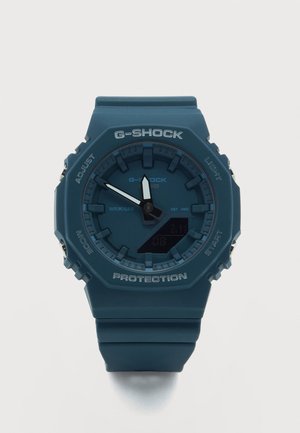 Σκούρο μπλε αναλογικό-ψηφιακό ρολόι G-Shock με ρητίνη λουράκι, δείχνει 11:55, με κουμπιά σημειωμένα Adjust, Mode, Light και Start.
