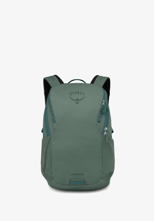 Mochila Osprey Astronova en tela verde apagado, con una textura suave, cremalleras laterales dobles, correas ajustables y un logo decorativo.