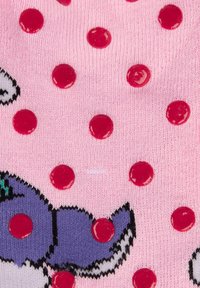 Tessuto a maglia rosa con pois rossi lucidi, con un'illustrazione di un personaggio dei cartoni animati in viola, nero e accenti verdi.