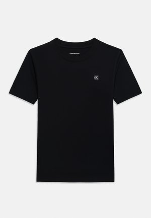 Mustavärinen, lyhythihainen pyöreäkauluksinen T-paita, jossa vasemmassa rinnassa pieni valkoinen "cK"-logo ja kauluksessa teksti "Calvin Klein Jeans".