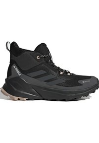 Scarpa da trekking Adidas Terrex alta nera con Gore-Tex, suola testurizzata, strisce riflettenti e lacci con motivo, progettata per l'uso all'aperto.