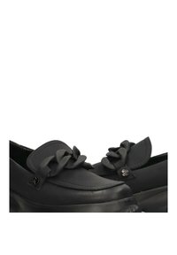 Mocasines negros de material sintético con detalle de cinta en la parte delantera, puntera redondeada y suela de plataforma gruesa.