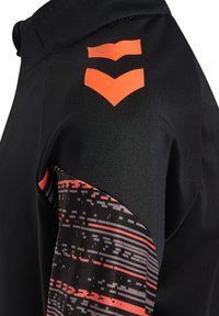 Schwarzes Sportshirt mit einem strukturierten schwarzen und roten gemusterten Ärmel und drei orangefarbenen Chevron-Streifen auf der Schulter.