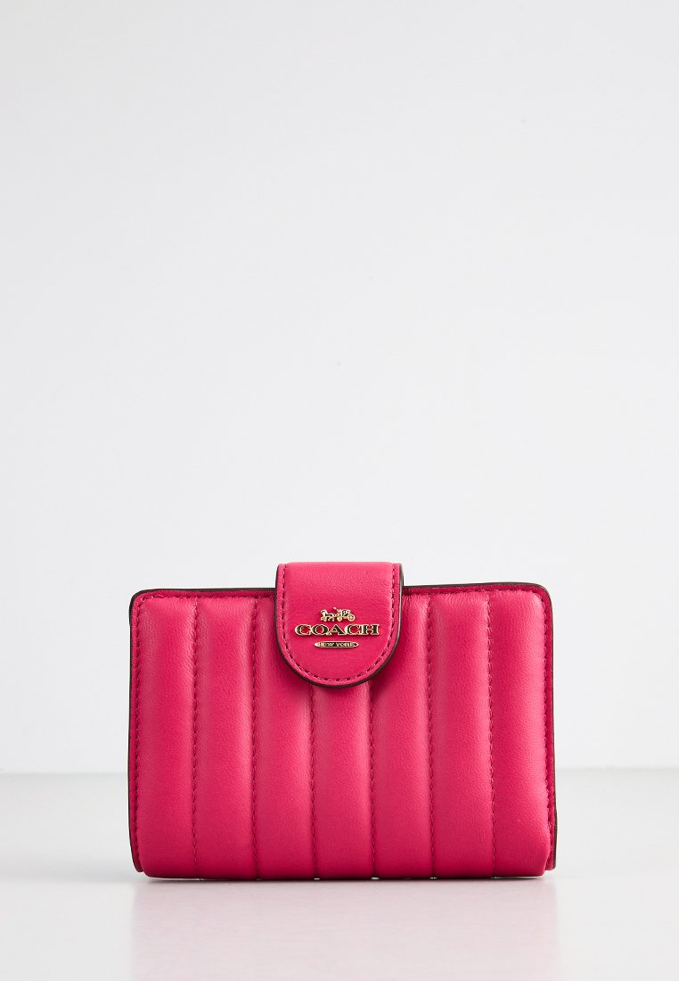 Różowy skórzany portfel z pikowanym wzorem, z magnetycznym zapięciem na zatrzask i złotym akcentem logo z przodu. Kompaktowy i prostokątny kształt.