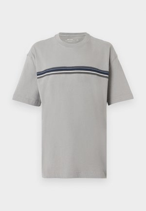 Camiseta de manga corta de cuello redondo en gris claro con franjas horizontales en azul marino, blanco y negro en el pecho.