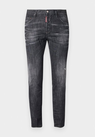 Jeans de ganga cinza escuro com um ajuste slim, desbotamento sutil, marcas de desgaste nas coxas, cinco bolsos e um detalhe de etiqueta vermelha em contraste.