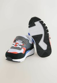 Grå og sorte sneakers med røde og blå detaljer, lavet af mesh og semsket læder, med et Spider-Man-logo på den elastiske rem. Gummisål.