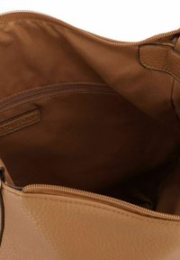 Innenseite einer handgefertigten Tasche aus braunem Leder mit gefüttertem Stofffutter. Sie verfügt über eine Reißverschlusstasche und ein dezentes Markenlabel. Weiche Textur und geräumiges Design.