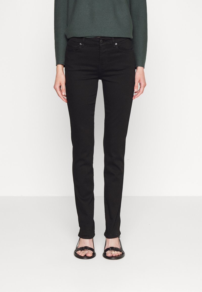 Black skinny jeans with a low rise, five pockets, and silver hardware. Made of denim with a smooth texture, featuring a classic design.