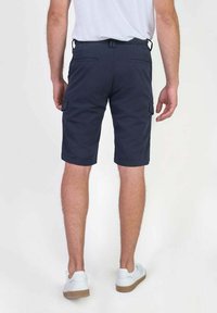 Marine cargoshorts gemaakt van duurzame materialen, voorzien van zijzakken, een relaxed fit en een middellange snit. In combinatie met witte sneakers.
