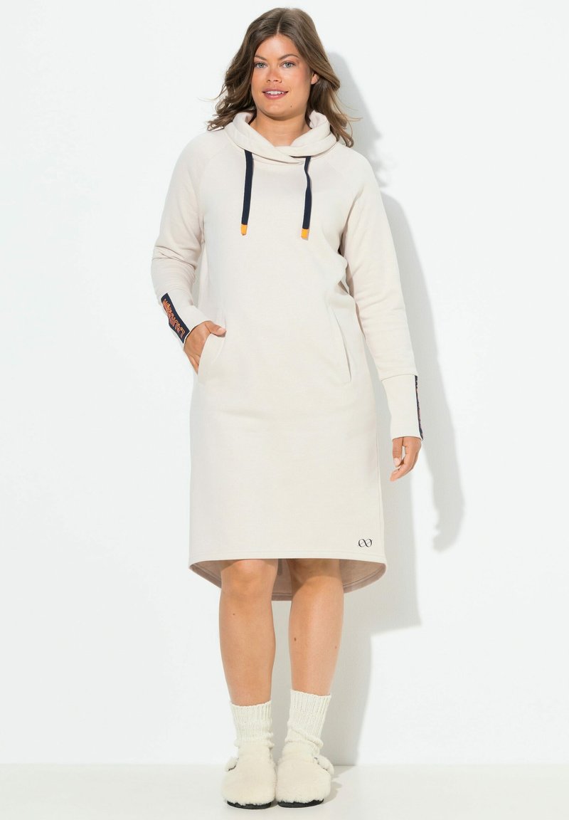 Sweatshirt jurk in lichtbeige, met capuchon, marineblauwe touwtjes,zijzakken en een logo nabij de zoom. Geribbelde gebreide mouwen en boorden.