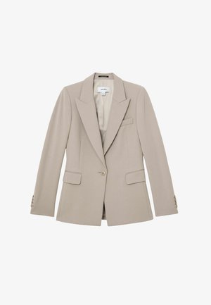 Bēša piegriezuma žakete ar vienu pogu, ar atveramām atlokiem, kabatām ar atlokiem un pogu detaļām uz aprocēm.