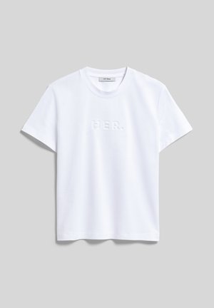T-shirt blanc à manches courtes et col rond avec texte en relief "HER." au centre et une petite étiquette à l'intérieur du col.