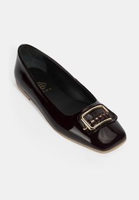 Chaussure plate en cuir verni bordeaux avec un bout carré, dotée d'une boucle décorative en or et d'un accent tissé à l'avant.