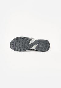 Merrell hiking shoe sole in dark gray rubber with a textured pattern for grip, featuring a white accent and a defined tread design.